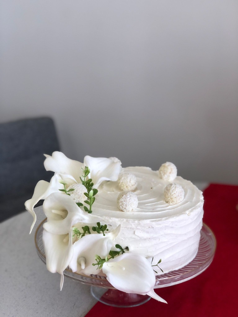 Beyaz gala çiçekleri ve Hindistan cevizli toplarla dekore edilmiş zarif pasta