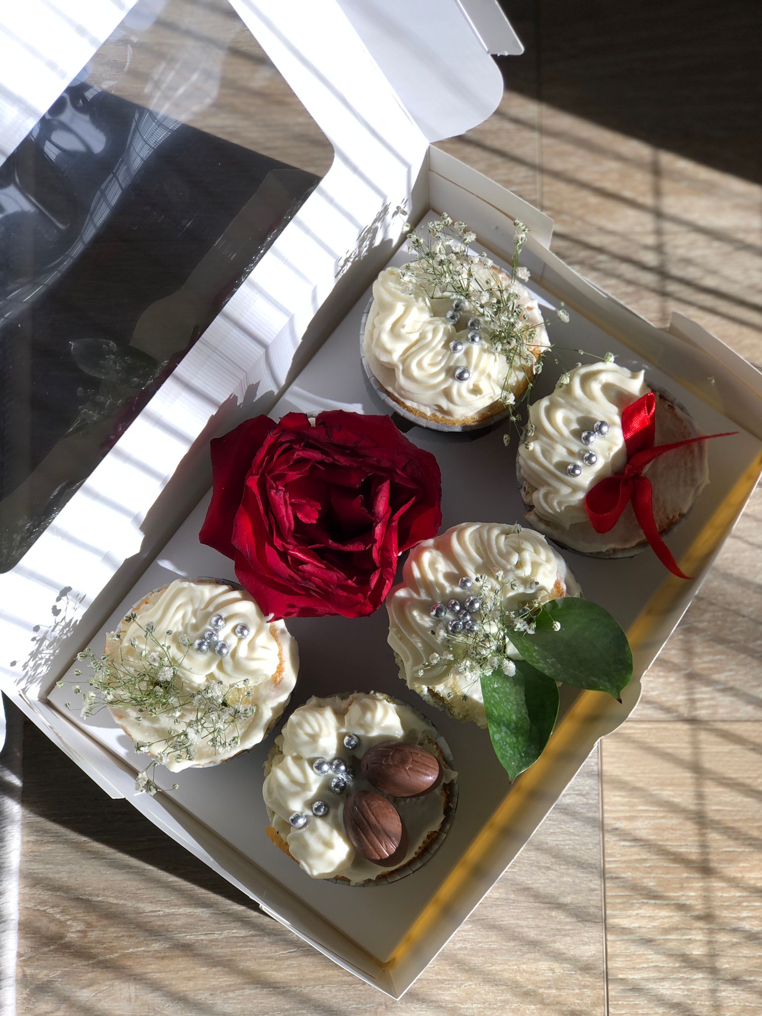 Kırmızı gül, gümüş inciler ve cipso çiçeklerle süslenmiş cupcake kutusu